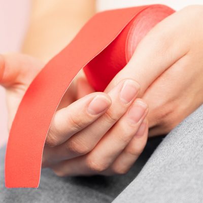 close-up-red-kinesio-tape-female-hands-kinesiology-physical-therapy-rehabilitation-concept